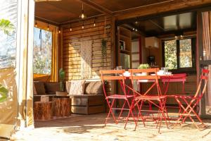 patio z czerwonymi krzesłami i stołem na ganku w obiekcie Camping 3 étoiles - Parc aquatique - eecehf w Fréjus