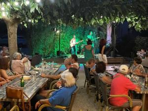 un grupo de personas sentadas en mesas viendo un concierto en Camping 3 étoiles - ccaaafd, en Sorèze 135 fotos más