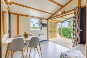 a dining room with a table and chairs at ZEcamping 3 étoiles familial animaux acceptés piscine couverte et chauffée in Saint-Hilaire-de-Talmont