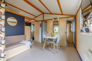 a room with a bed and a table and chairs at ZEcamping 3 étoiles familial animaux acceptés piscine couverte et chauffée in Saint-Hilaire-de-Talmont