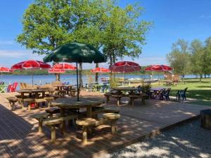 a group of picnic tables and umbrellas on a deck at ZEcamping 3 étoiles pet friendly avec sauna bar et restaurant in Priziac +46 photos