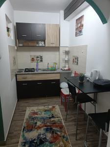 een keuken met een tafel en een wastafel en een tafel en stoelen bij Apartament terasa in Boekarest