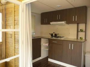 a kitchen with brown cabinets and a counter top at ZEcamping 4 étoiles chiens acceptés bien-être piscine couverte in Azur