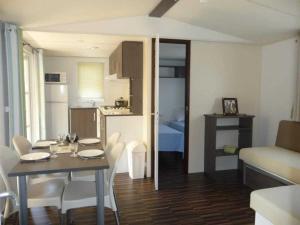 a room with a table and chairs and a kitchen at ZEcamping 4 étoiles chiens acceptés bien-être piscine couverte in Azur