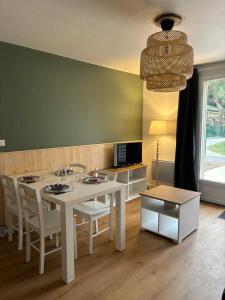 ein Esszimmer mit einem weißen Tisch und Stühlen in der Unterkunft Camping 4 étoiles - Piscine - ccafgbh in Saint-Hilaire-de-Riez