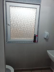 een badkamer met een raam, een toilet en een wastafel bij Apartament terasa in Boekarest