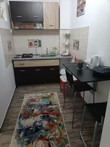 een keuken met een tafel en een keukenkleed op de vloer bij Apartament terasa in Boekarest +6 foto's
