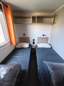 Cette petite chambre comprend 2 lits. dans l'établissement Bungalow proche mer CARRY LE ROUET, à Carry-le-Rouet