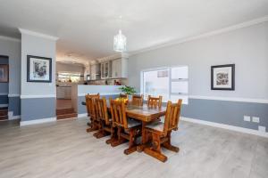 a kitchen and dining room with a wooden table and chairs at 163 on Kusweg in Hartenbos