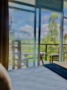 a bedroom with a bed and a large glass window at Master Villa in Bandarawela