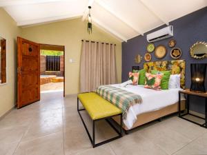 Zabini Lodge Rooms With Private Pools في نيلسبروت: غرفة نوم بها سرير وكرسي أصفر +43 صورة