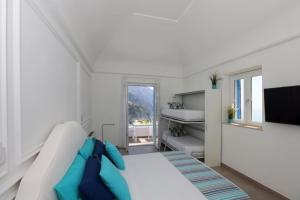 une chambre blanche avec un lit et une télévision dans l'établissement B&B Positano, à Giugliano in Campania