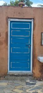 Una puerta de garaje azul en el costado de un edificio en WoodPacker Hostel Pondicherry, en Auroville