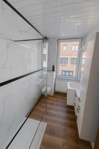 ein Badezimmer mit Waschbecken und Toilette und einem Fenster in der Unterkunft Maison cosy avec terrasse et jardin - Aéroport gare in Charleroi