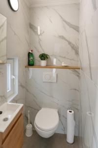 ein weißes Badezimmer mit Toilette und Waschbecken in der Unterkunft Maison cosy avec terrasse et jardin - Aéroport gare in Charleroi + 13 Fotos