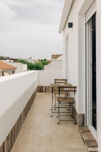 un balcon avec des chaises et une table sur un immeuble dans l'établissement Lola3 Apartamento VUT, à Lucena