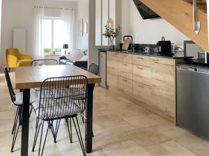 a kitchen with a wooden table and chairs at La Cour Tellier in Rilly-la-Montagne +25 photos