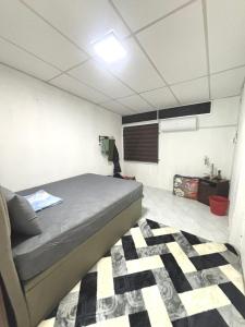 a bedroom with a bed and a checkered floor at Homestay Abah , Kota Bharu, Kelantan in Kota Bharu