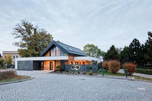 ein Haus mit einem schwarzen Dach und einer Auffahrt in der Unterkunft Chata Ostříž in Hlinsko