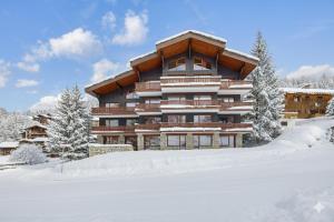 un grand bâtiment avec de la neige devant lui dans l'établissement Les Arolles - La Plagne 1800, à La Plagne Tarentaise