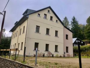 a large white building with a black roof at Nature Apartment in Albrechtice v Jizerských horách