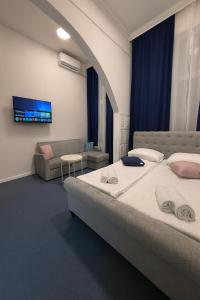 Un dormitorio con una cama grande y un sofá. en Royal Blue Central Point, en Sarajevo