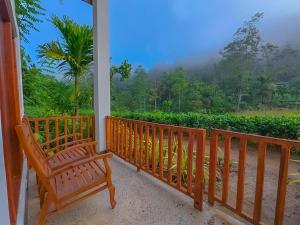 een veranda met 2 banken en uitzicht op de bergen bij Sinharaja Rainforest Vibe in Deniyaya