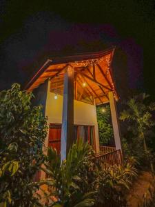une maison avec un porche avec des lumières dessus dans l'établissement Sinharaja Rainforest Vibe, à Deniyaya