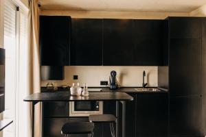 une cuisine noire avec des armoires et des tabourets noirs dans l'établissement Lola3 Apartamento VUT, à Lucena 6 autres photos