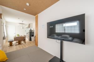 ein Wohnzimmer mit einem Flachbildfernseher an der Wand in der Unterkunft O's Apartment Hotel In Kyobashi 3FA in Osaka