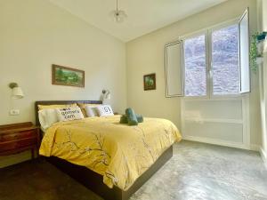 een slaapkamer met een bed met een geel dekbed en een raam bij Casa Orijamas in Calera