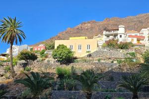 een stad op een heuvel met palmbomen en gebouwen bij Casa Orijamas in Calera