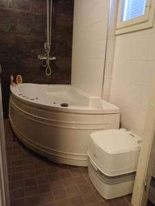 a bathroom with a white tub and a toilet at Huilikammari in Seinäjoki
