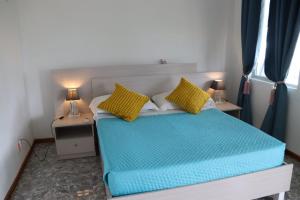 1 dormitorio con 1 cama azul y 2 almohadas amarillas. en Panoramic Seaview suite, en Trou d'Eau Douce
