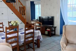 a living room with a staircase and a television at Maison en bord de mer in Réville
