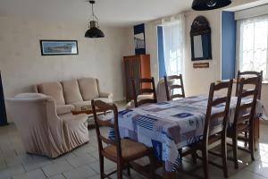 a living room with a table and chairs and a couch at Maison en bord de mer in Réville