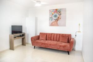 a living room with a orange couch and a painting at Panoramic View in Ducos