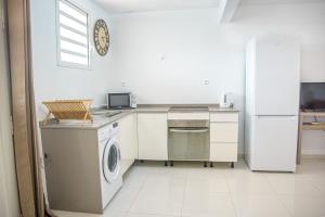 a kitchen with a washing machine and a refrigerator at Panoramic View in Ducos +1 photo