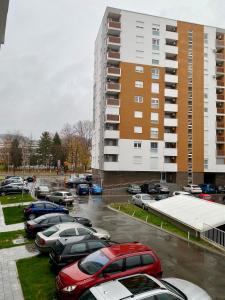 un parking avec des voitures garées devant un bâtiment dans l'établissement FILIP Lux Apartman sa garažom, à Doboj