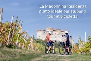 two people riding bikes in front of a castle at Residenze La Madonnina in Vigatto