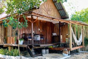 a wooden house with a table and chairs in it at Baanlamun in Ban Dong Bang