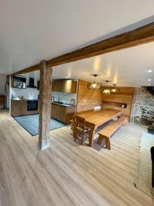 ein Esszimmer mit einem Holztisch und einer Küche in der Unterkunft Camp de Base - retraite d'exception 16 personnes in Les Orres