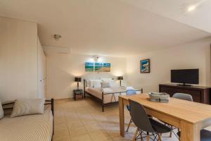 Una sala de estar con una mesa y una cama. en Mani's Aura Seaside-Enchanting Stone Gem, en Kotrónion