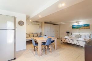 una habitación con una mesa y sillas y una cama en Mani's Aura Seaside-Enchanting Stone Gem, en Kotrónion