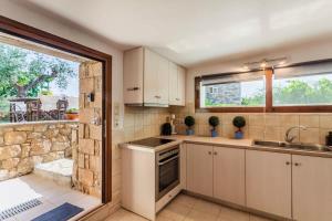 Una cocina con fregadero, estufa y ventana. en Mani's Aura Seaside-Enchanting Stone Gem, en Kotrónion 16 fotos más