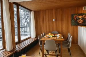 シャモニー・モンブランにあるBright apartment for 6 people in Chamonixのテーブルと椅子と窓のあるダイニングルーム