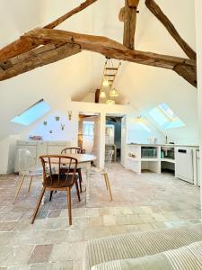 una cucina con un tavolo e sedie in una stanza di L'Ecrin Saint Denis, petite au centre d'Amboise! a La Celle-sous-Gouzon