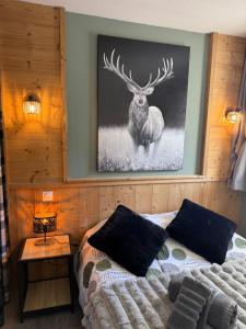 ein Schlafzimmer mit einem Bett und einem Bild eines Hirsches in der Unterkunft Logement cosy à la montagne in Bourg-Saint-Maurice + 8 Fotos