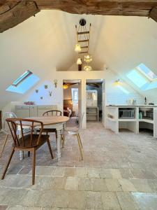 una cucina e un soggiorno con tavolo e sedie di L'Ecrin Saint Denis, petite au centre d'Amboise! a La Celle-sous-Gouzon Altre 33 foto