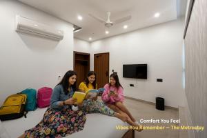 three girls sitting on the floor reading books at Metro POD Hotel at New Delhi Metro & Railway Station in New Delhi
